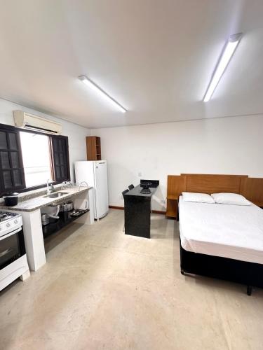 a large room with a bed and a kitchen at Recanto Vizinho do Mar in Ubatuba