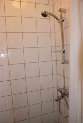 a shower with a shower head in a bathroom at Cozy small bedroom flat in Trondheim
