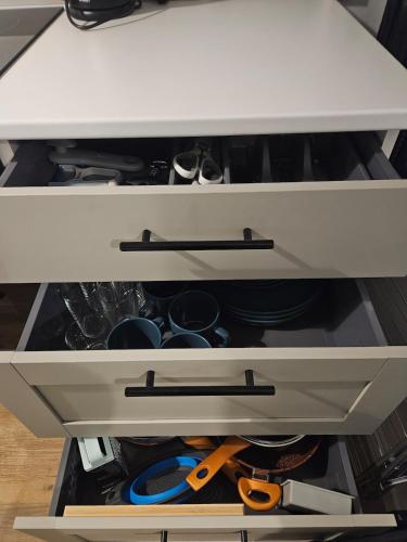 a drawer with pots and pans in a kitchen cabinet at The Dell - Rushden Lakes in Rushden