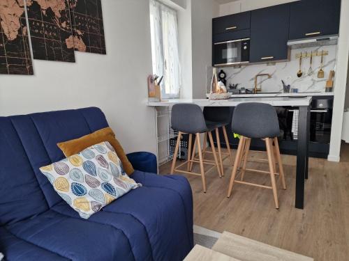 un salon avec un canapé bleu et une cuisine dans l'établissement Le marsault, à Les Sables-dʼOlonne