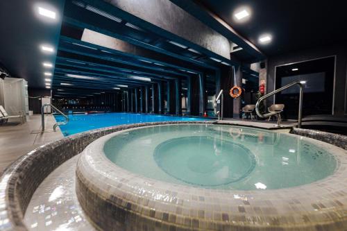 a jacuzzi tub in a building with a pool at Wellness Spa Suite by the Opera in Budapest