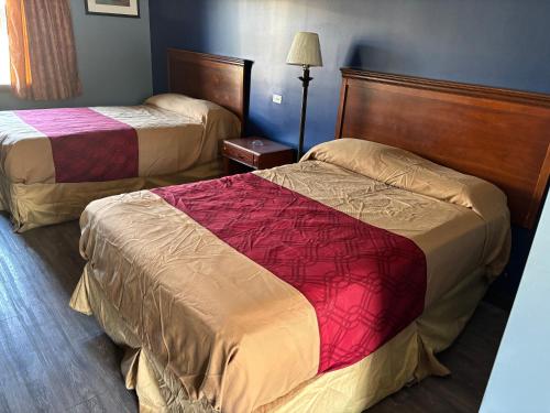 a hotel room with two beds and a lamp at Budget Inn Express in Augusta