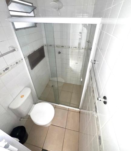 a bathroom with a toilet and a glass shower at Recanto Vizinho do Mar in Ubatuba