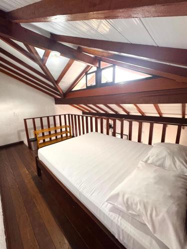 a large bed in a room with a wooden ceiling at Recanto Vizinho do Mar in Ubatuba