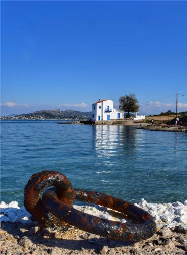 a rusty chain on the shore of a body of water at Villa Aelia Luxury Maisonette in Salamís