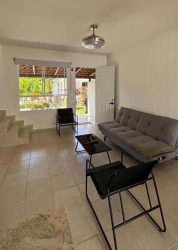 a living room with a couch and a table at Villa familiar en Playa del Carmen con alberca in Playa del Carmen