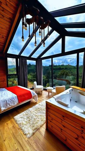 a bedroom with a bed and a large window at paradise valley bungalow in Ardeşen