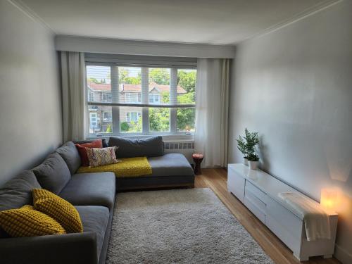 a living room with a couch and a large window at Large & bright 3 bedroom in MTL in Montréal