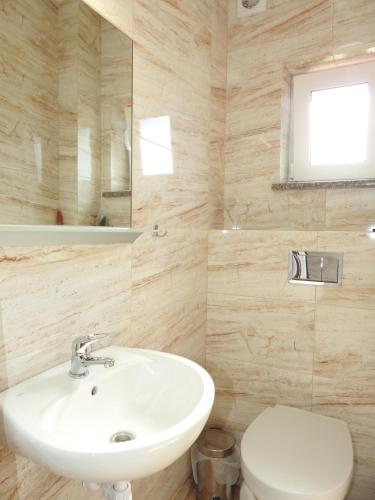 a bathroom with a sink and a toilet at Elizabeth Łeba - Pokoje Gościnne in Łeba