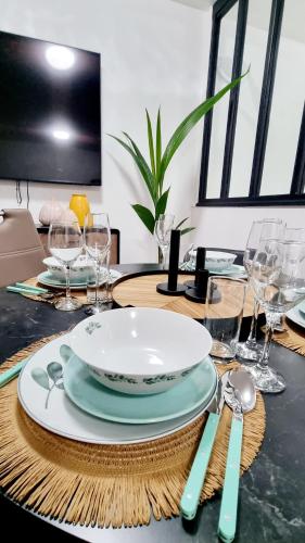 une table avec une plaque sur une table et des verres dans l'établissement Studio contemporain aux portes de Genève, à Ferney-Voltaire