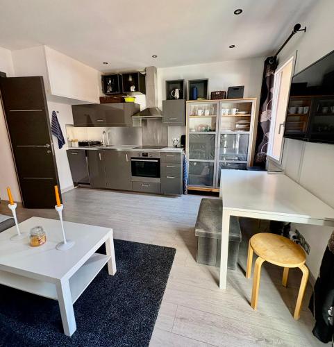 une grande cuisine avec une table blanche et une table blanche dans l'établissement Appartement moderne et entièrement rénové en plein cœur du village, chambre séparée, balcon vue montagne, très proche des pistes, à Tignes