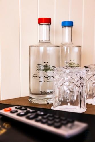 a bottle of whiskey and a remote control on a table at Hotel Fliegerheim in Borkheide