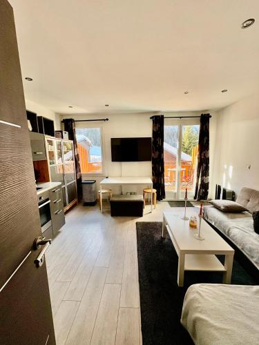 un grand salon avec un canapé et une table dans l'établissement Appartement moderne et entièrement rénové en plein cœur du village, chambre séparée, balcon vue montagne, très proche des pistes, à Tignes