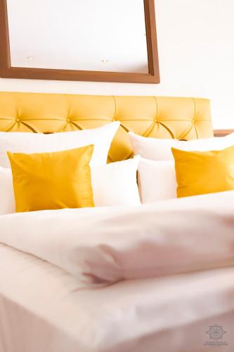 a close up of a bed with yellow pillows at Hotel Fliegerheim in Borkheide