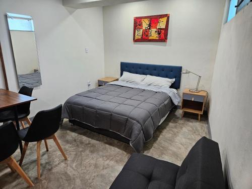 a bedroom with a bed and a table and chairs at Relaxed and private in Jiquilpan de Juárez
