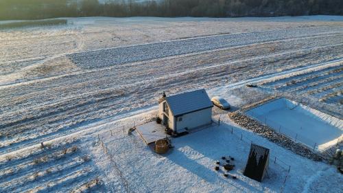an aerial view of a snow covered field with a barn at Gospodarstwo Agroturystyczne Borówkowy Bukiet Smaków in Iwkowa