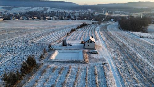 a small house in the middle of a snow covered field at Gospodarstwo Agroturystyczne Borówkowy Bukiet Smaków in Iwkowa