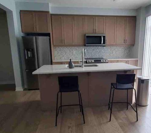 a kitchen with a sink and two bar stools at Lovely 2 bedroom 2 bath in Ottawa