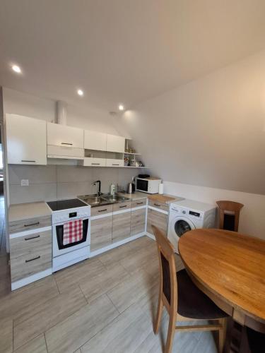 una cucina con armadi bianchi, tavolo e piano cottura di Noclegi, agroturystyka, pokoje a Konstantynów