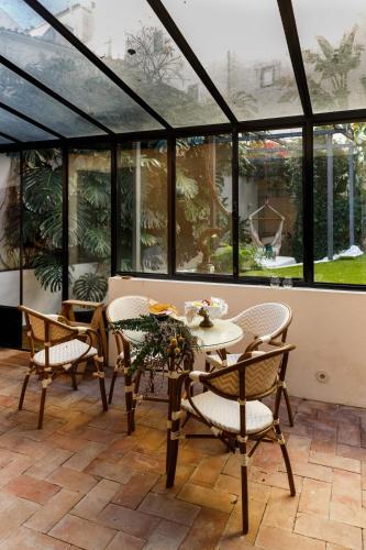 a conservatory with a table and chairs and windows at Pool & Garden Apt In the Heart of Lisbon in Lisbon