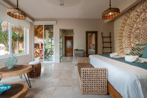 a bedroom with a large bed and a table and chairs at Rojo Manglar Acapulco in Acapulco