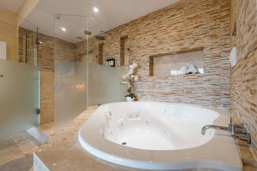 a large white bath tub in a bathroom at Rojo Manglar Acapulco in Acapulco