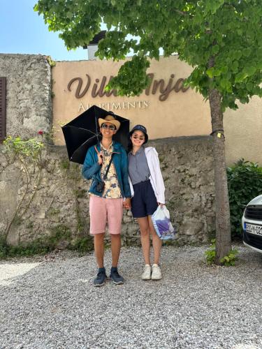 a man and a woman standing under an umbrella at Villa Anja Apartments in Mostar