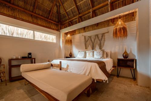 a bedroom with two beds and a chair in it at Rojo Manglar Acapulco in Acapulco