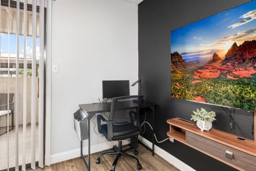 an office with a desk and a monitor on a wall at Luxury Tempe Retreat Pool Gym WiFi in Tempe