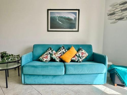 - un canapé bleu avec des oreillers dans le salon dans l'établissement Risso - charming one bedroom with a balcony, à Nice