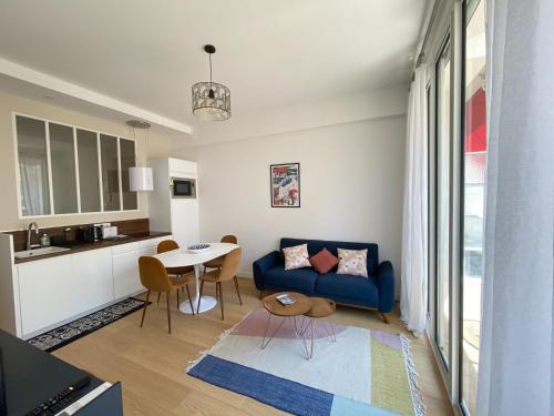 un salon avec un canapé bleu et une table dans l'établissement Mediterranee - un trois pièces à deux pas de la plage, à Nice