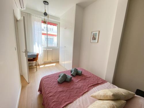 une chambre avec un lit avec deux oreillers dessus dans l'établissement Mediterranee - un trois pièces à deux pas de la plage, à Nice