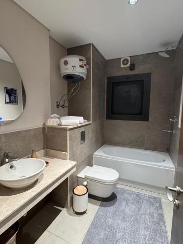 a bathroom with a tub and a toilet and a sink at Zed towers El sheikh ZAYED zed park 3 in Sheikh Zayed