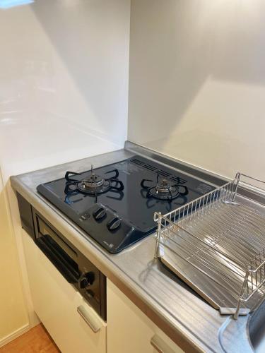 a kitchen with a stove and a drying rack at Chill Fortuna Shimokitazawa Tokyo in Tokyo
