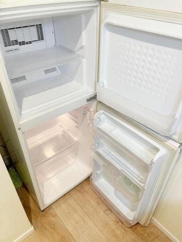 an empty refrigerator with its door open in a kitchen at Chill Fortuna Shimokitazawa Tokyo in Tokyo