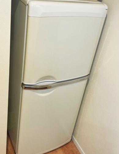 a white refrigerator freezer sitting in a room at Chill Fortuna Shimokitazawa Tokyo in Tokyo