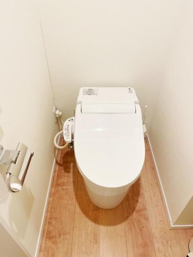 a white toilet in a bathroom with a wooden floor at Chill Fortuna Shimokitazawa Tokyo in Tokyo