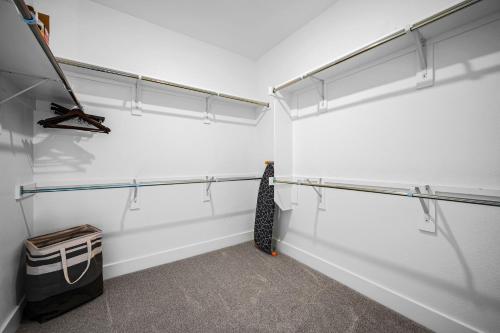 a walk in closet with white walls and metal racks at Charming Lake House Retreat In Rowlett in Rowlett