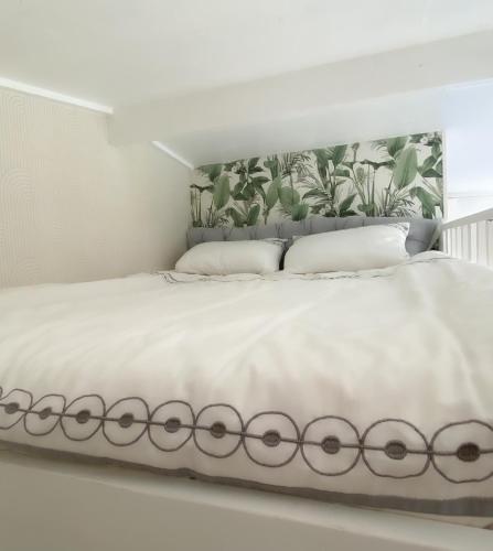 un lit blanc avec des draps et des oreillers blancs dans l'établissement Studio Cosy, à Saintes