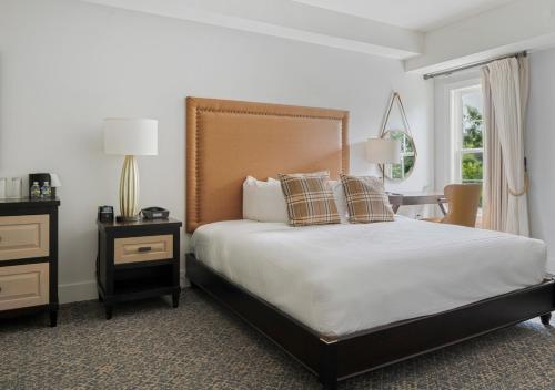 a bedroom with a bed and a table and a window at The Inn at Chesapeake Bay Beach Club in Stevensville