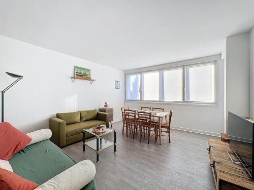 un salon avec un canapé et une table dans l'établissement Appartement Le balcon, à Dunkerque