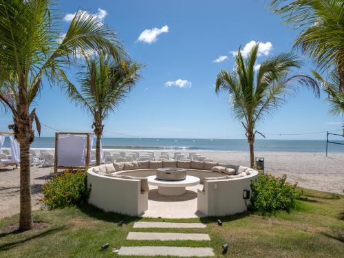 a hot tub on the beach with palm trees at Playa Caracol Apt with Radisson Hotel Amenities in El Quindio