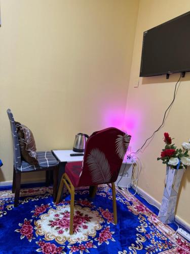 a room with a table and a chair and a television at MAMA DELiGHT HOME in Abu Dhabi