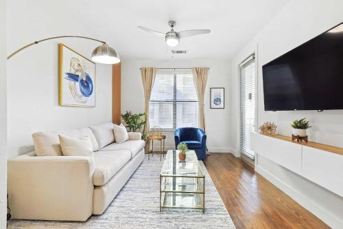 a living room with a white couch and a flat screen tv at Big and Spacious 1B with Pool Near Toyota HQ The Star Legacy West in Frisco