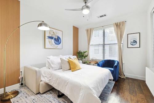 a bedroom with a white bed and a blue chair at Big and Spacious 1B with Pool Near Toyota HQ The Star Legacy West in Frisco