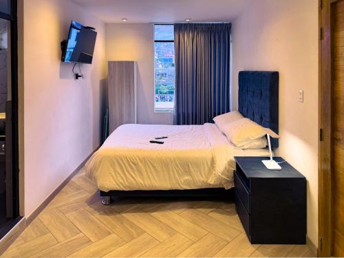 ein Hotelzimmer mit einem Bett und einem Fernseher in der Unterkunft Moderno Apto Estudio 01 in Cajamarca