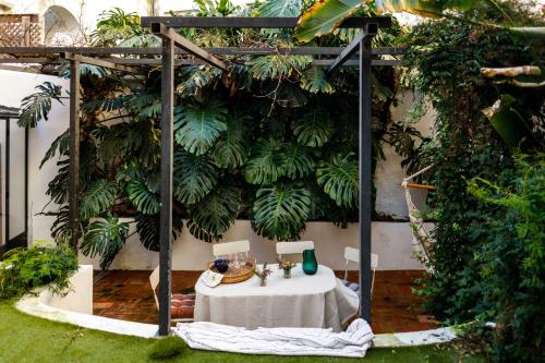 a table in front of a wall with plants at Pool & Garden Apt In the Heart of Lisbon in Lisbon