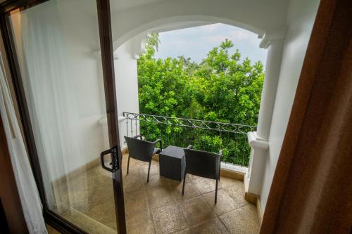 a balcony with two chairs and a window at Shana by the Beach Manuel Antonio in Manuel Antonio