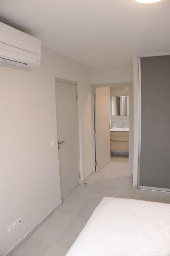 an empty white room with a bathroom and a sink at Le Soleil de Queenstone in Papeete