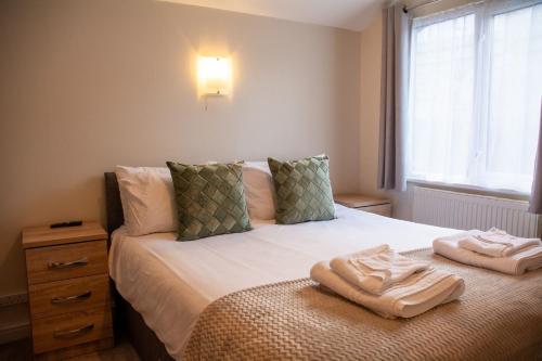 a bedroom with a bed with two towels on it at Y Caban in Cemaes Bay